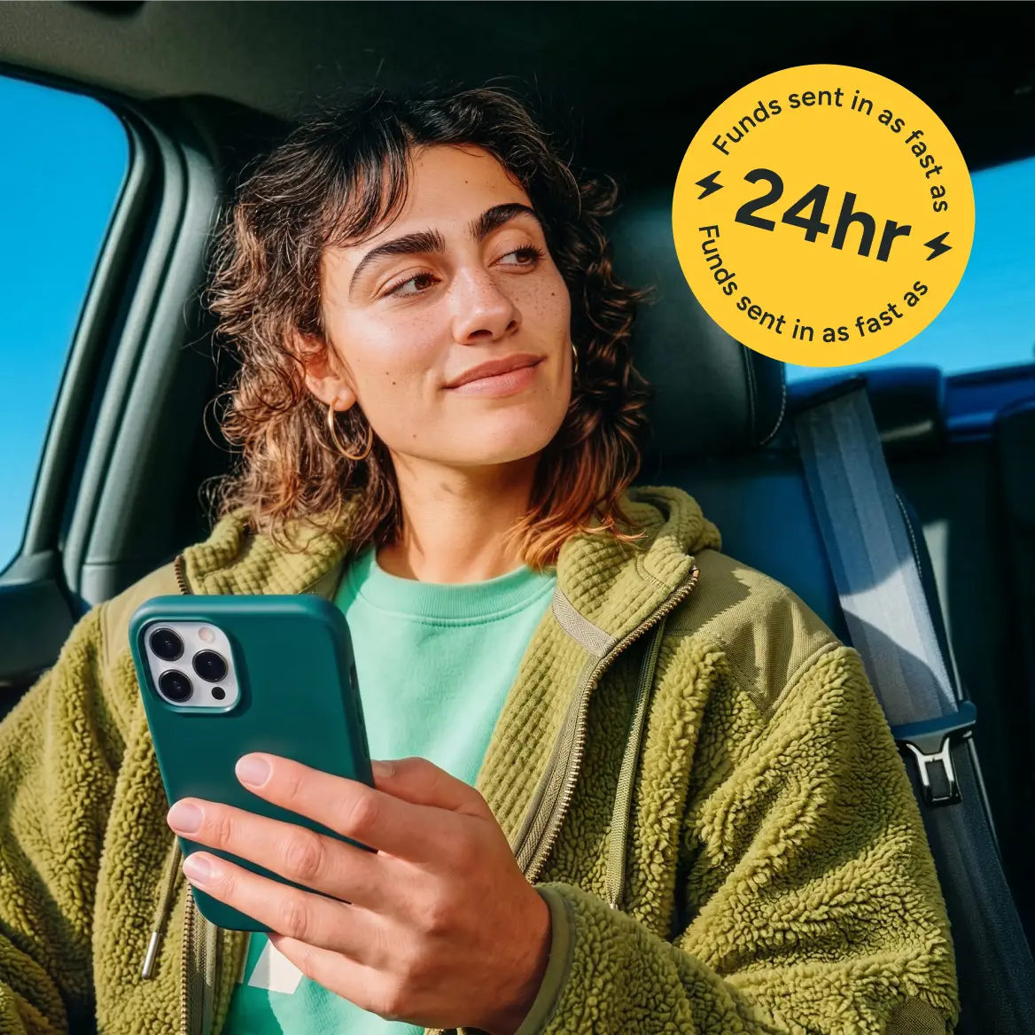 A woman sitting in a car and holding a phone
